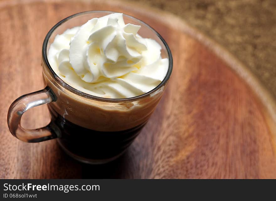 Glass cup of espresso coffee with white cream