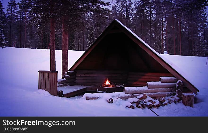 Winter forest. A lot of snow. Twilight. Lit a fire under a canopy for the tourists. Winter forest. A lot of snow. Twilight. Lit a fire under a canopy for the tourists