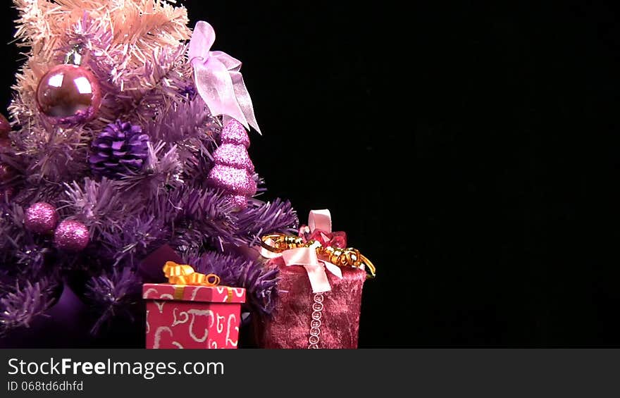 Decorated pink Christmas tree rotates on a black background. Decorated pink Christmas tree rotates on a black background