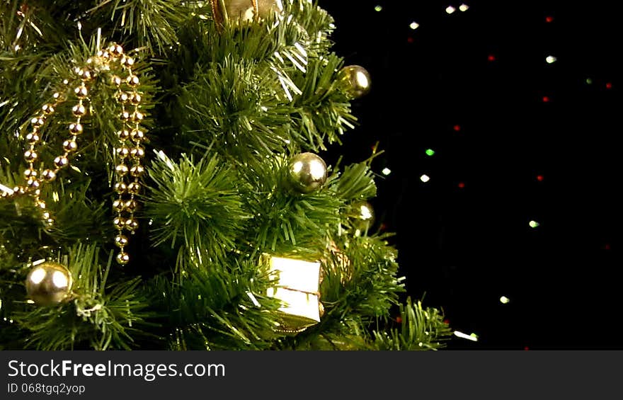 Decorated Christmas tree rotates on a black background with flashing lights