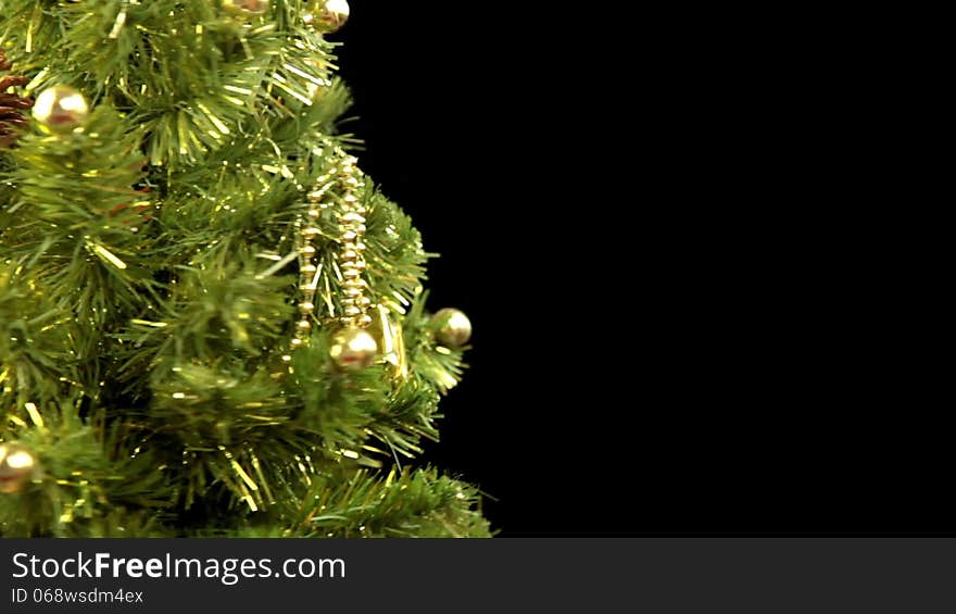 Black background. Decorated Christmas tree rotates. Focus moves to the foreground, where two wineglasses of red wine clinks. Sparkler wrote the inscription Merry Christmas!