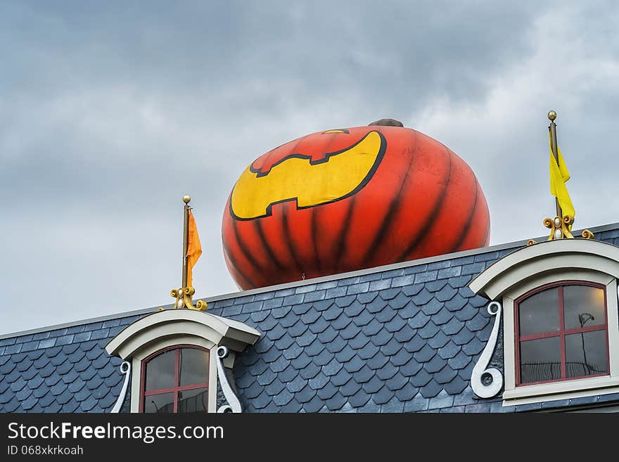 Giant pumpkin Halloween decoration on a roof. Giant pumpkin Halloween decoration on a roof