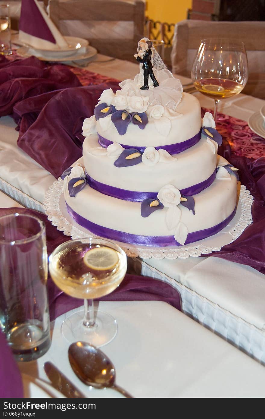 A three floored Wedding cake on a wedding table.