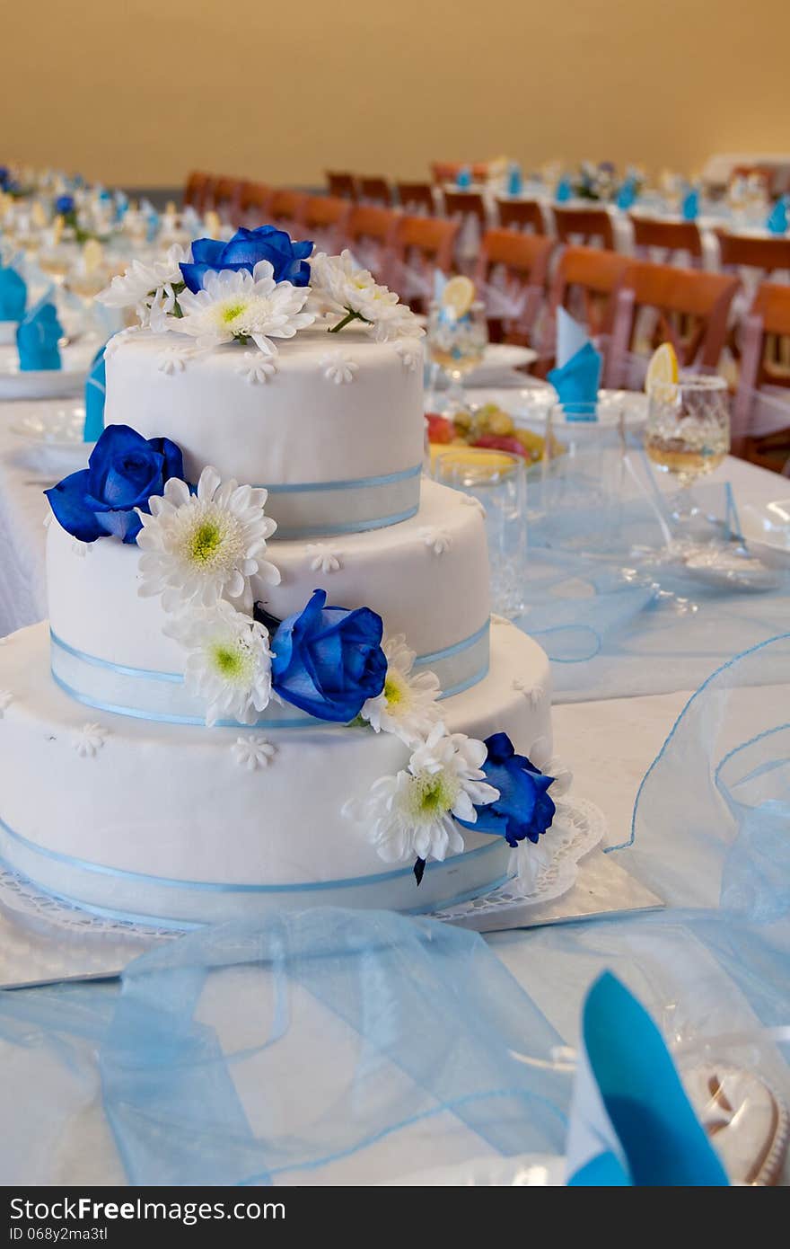 Wedding Cake with blue roses on a wedding table.