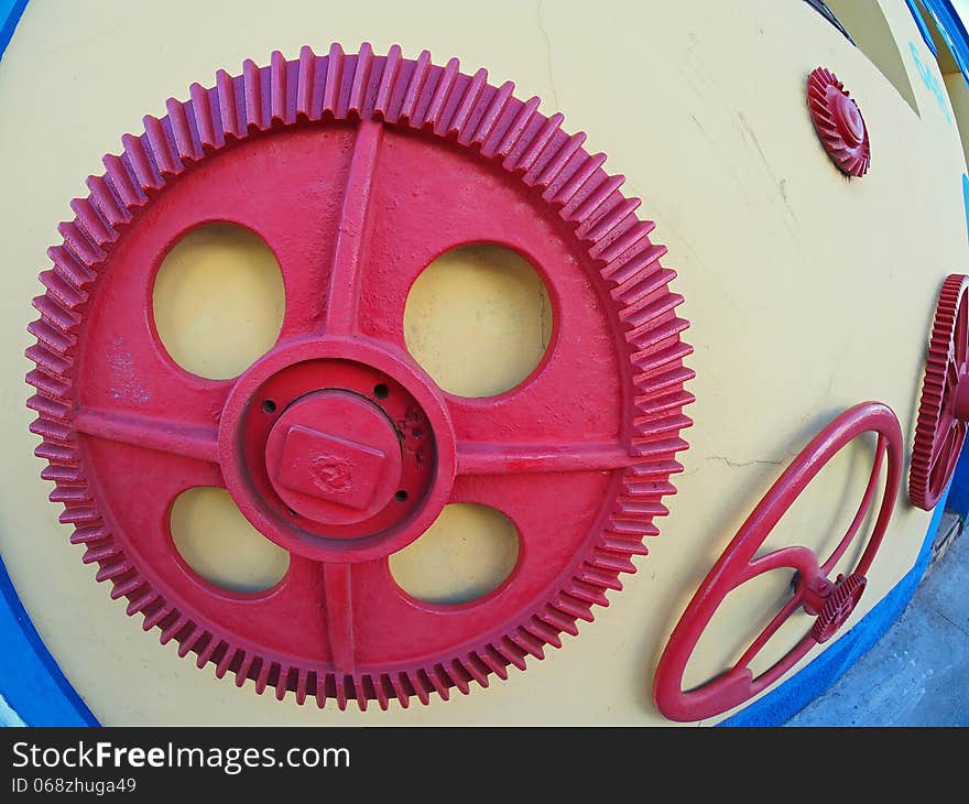 Red gear fixed on the yellow wall of a garage mechanic - Amazonia - Brazil