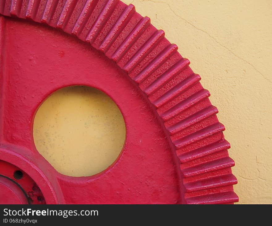 Red gear fixed on the yellow wall of a garage mechanic - Amazonia - Brazil