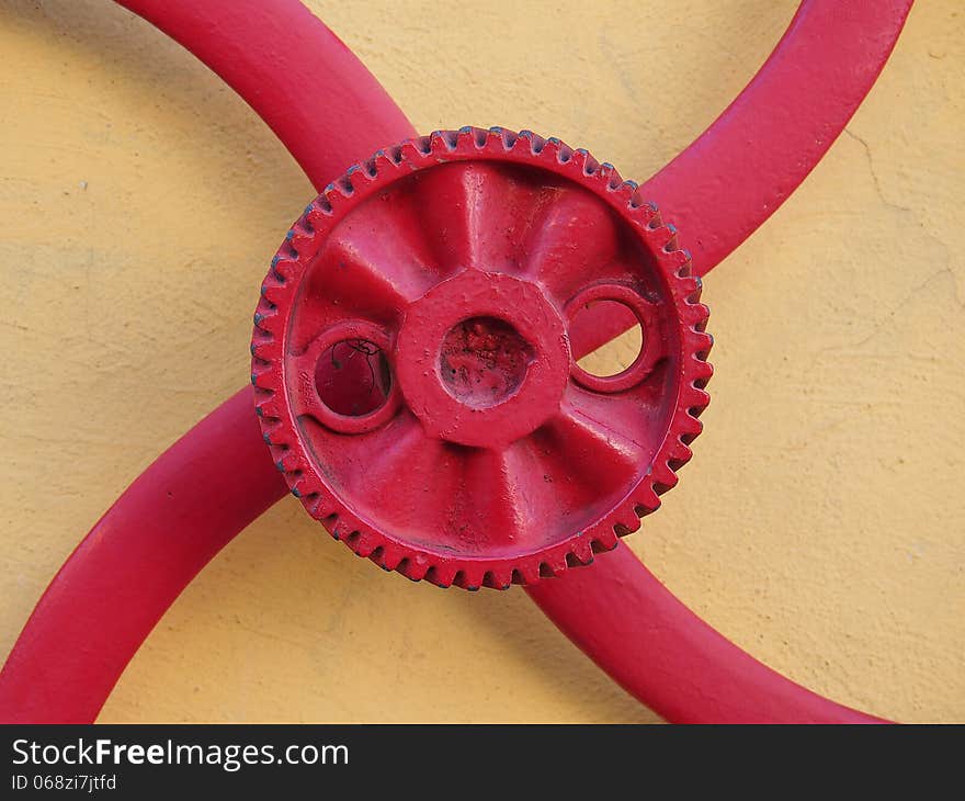 Red gear fixed on the yellow wall of a garage mechanic - Amazonia - Brazil