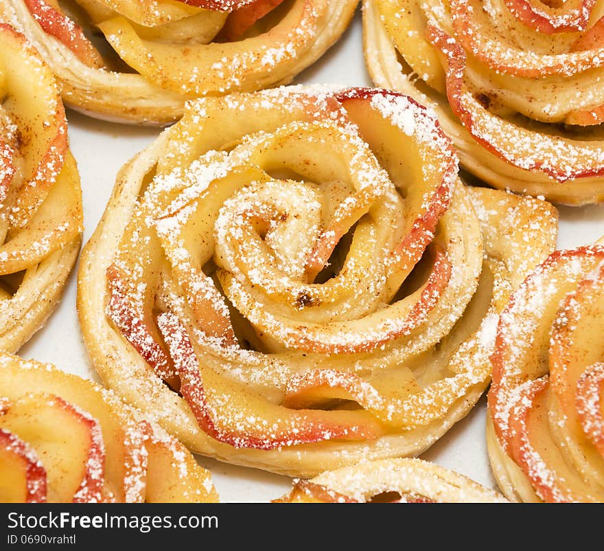 Sweet rolls with apples in the form of roses on white plate. Sweet rolls with apples in the form of roses on white plate