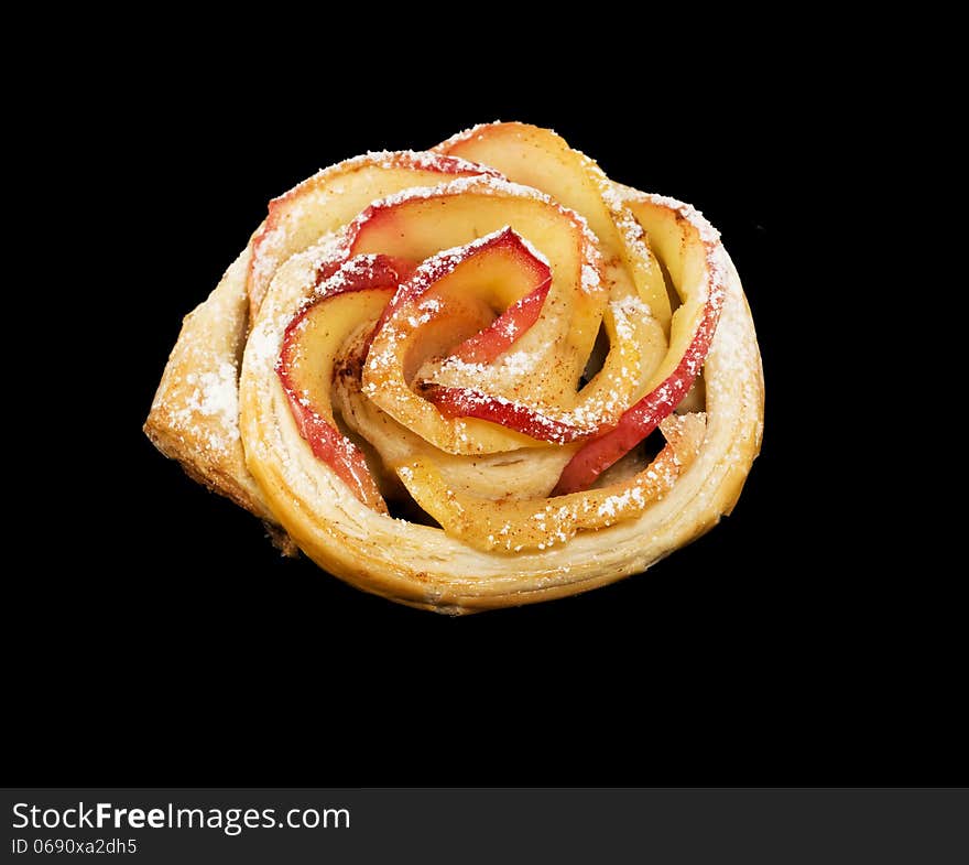 Sweet roll with apples in the form of roses on black  background