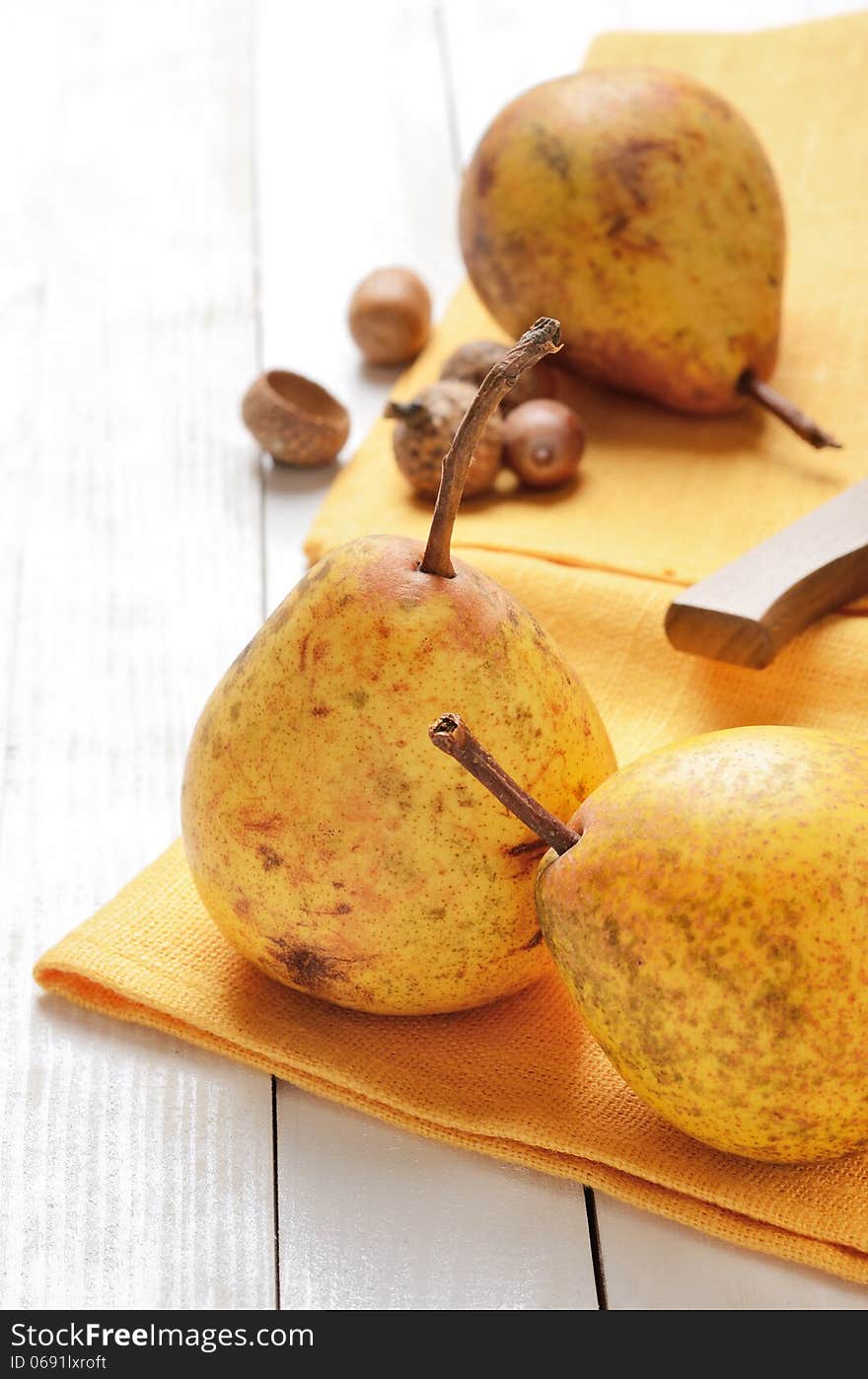 Ripe pears on a white wooden plank table