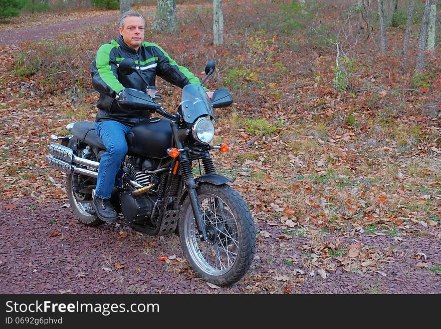 A man is shown on his motorcycle in the woods enjoying his sport and the outdoors. A man is shown on his motorcycle in the woods enjoying his sport and the outdoors.