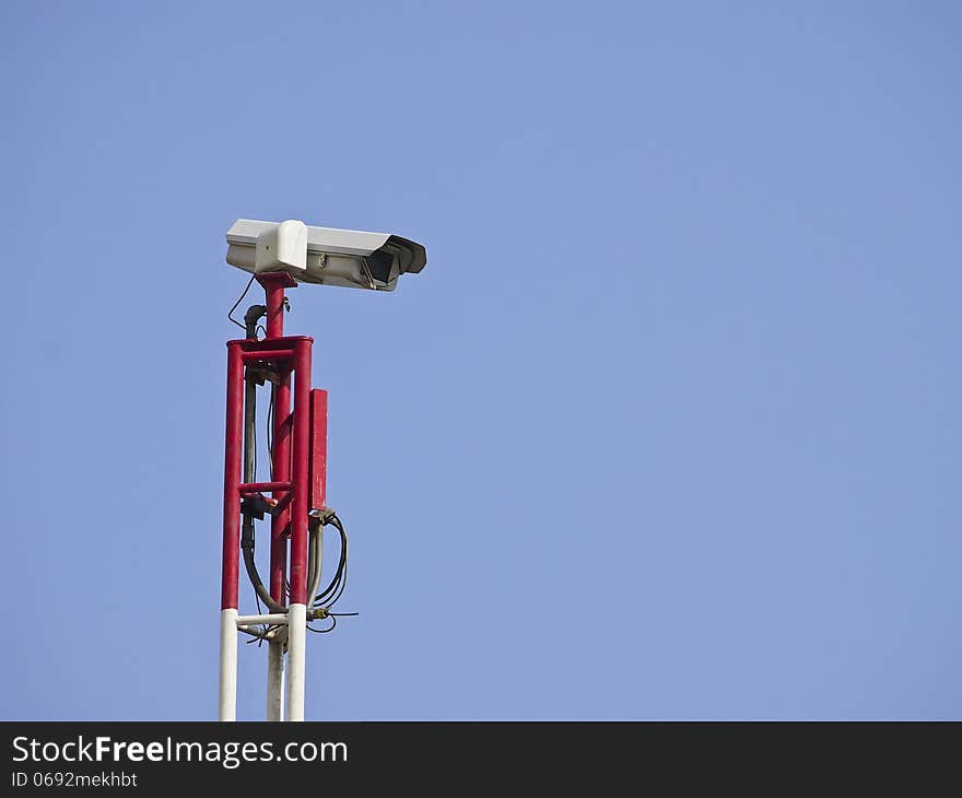 Security CCTV camera on top of pole in blue sky. Security CCTV camera on top of pole in blue sky