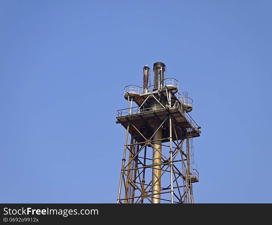 Peak of distillation tower in sunny day and blue sky