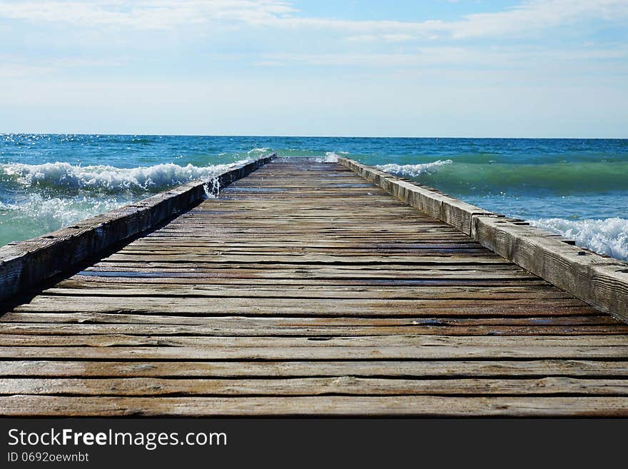 Wooden pier leading into the blue sea.