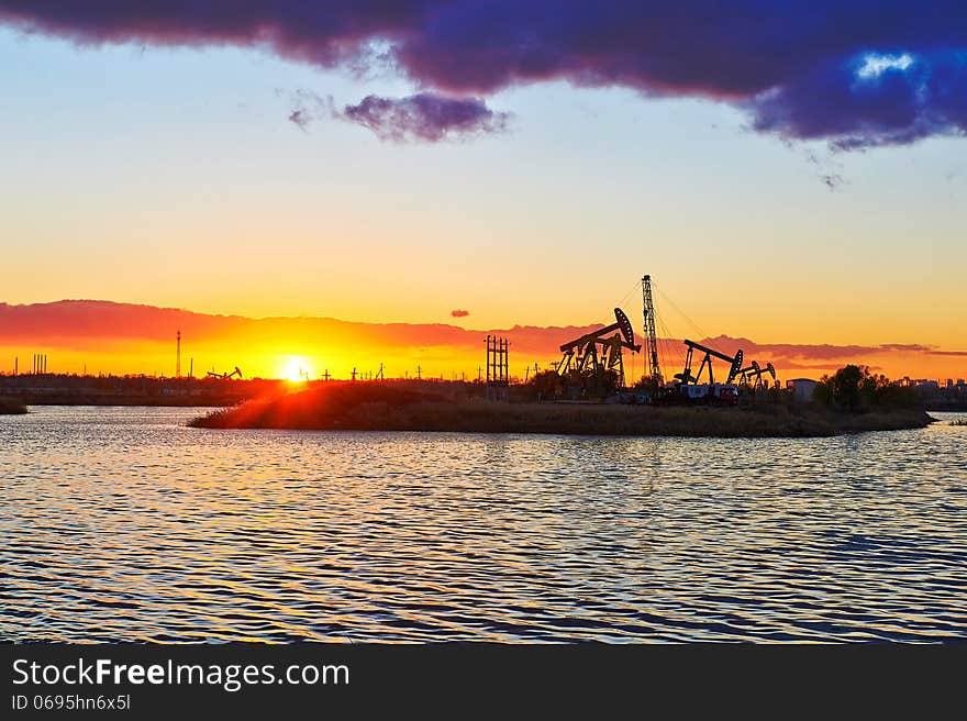 The oil sucking machine and lake sunset