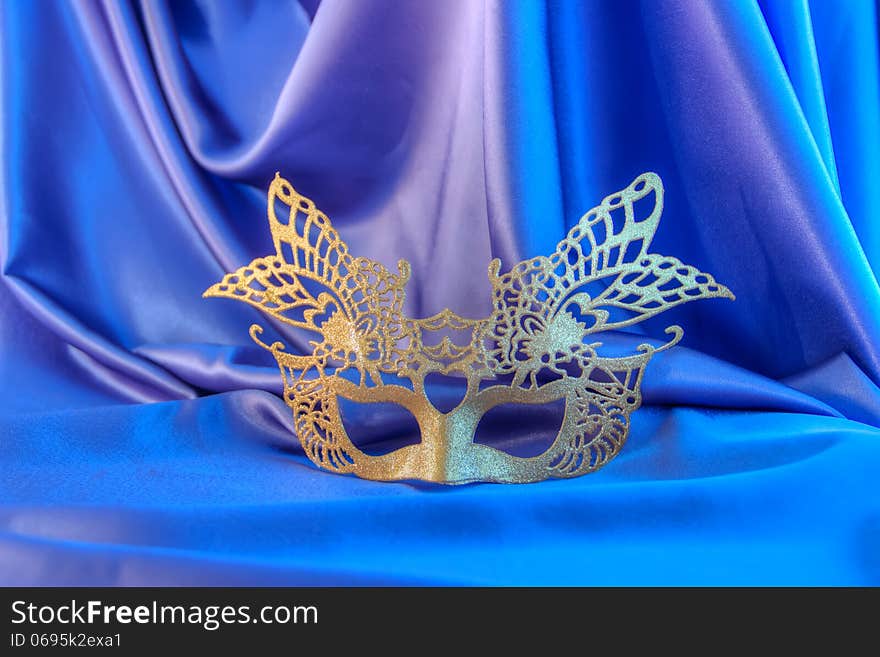 Carnival mask gold new year unisex against the background blue theater. Carnival mask gold new year unisex against the background blue theater