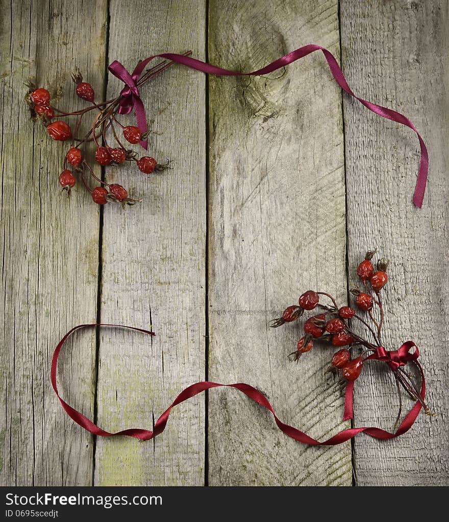 Vintage frame with berries and ribbons on wooden background. Vintage frame with berries and ribbons on wooden background