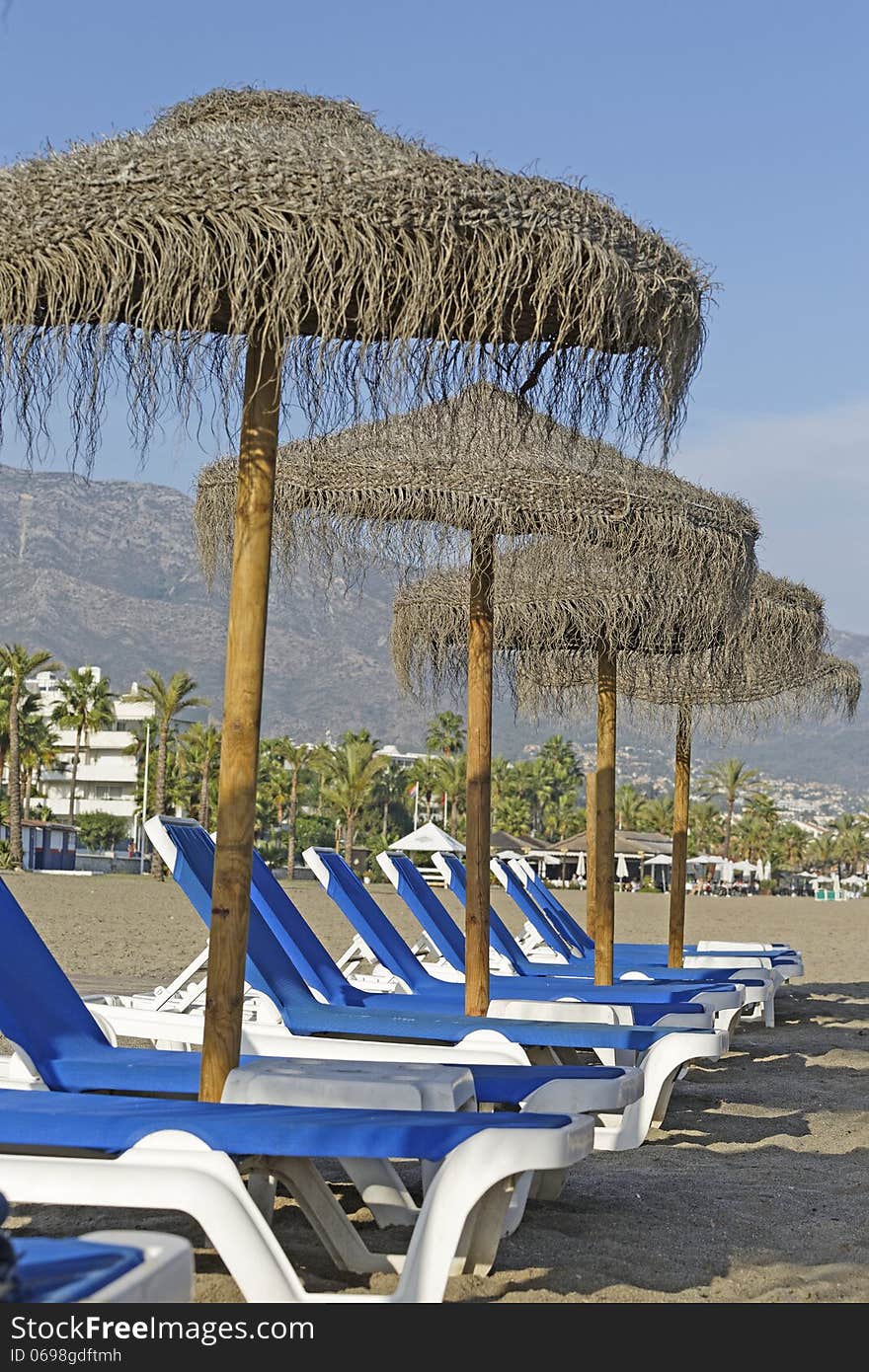 Image of beach umbrellas and beds taken in Marbella, spain