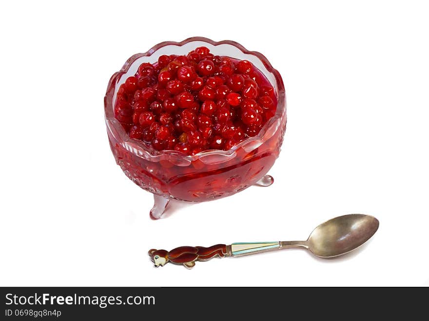 Bright red berries in a crystal vase filled with sugar syrup. Presented on a white background. Bright red berries in a crystal vase filled with sugar syrup. Presented on a white background.