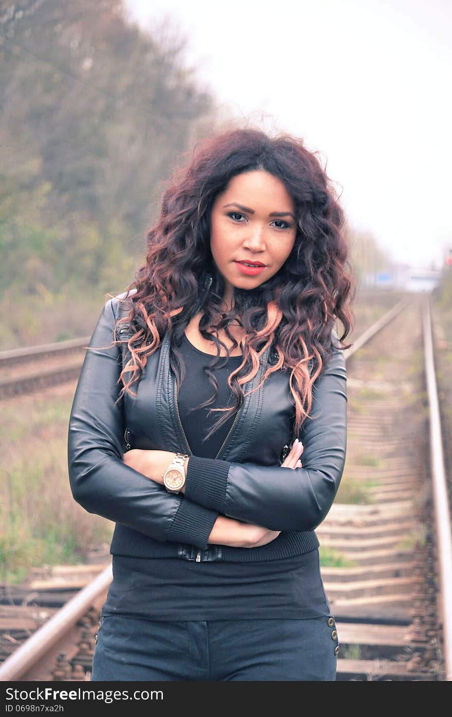 Portrait of an attractive young woman with long hair near railway. Portrait of an attractive young woman with long hair near railway.