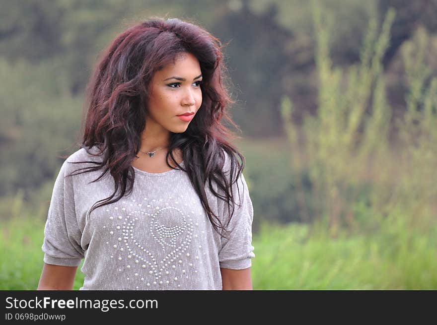 Outdoor portrait of an attractive young woman with long hair.