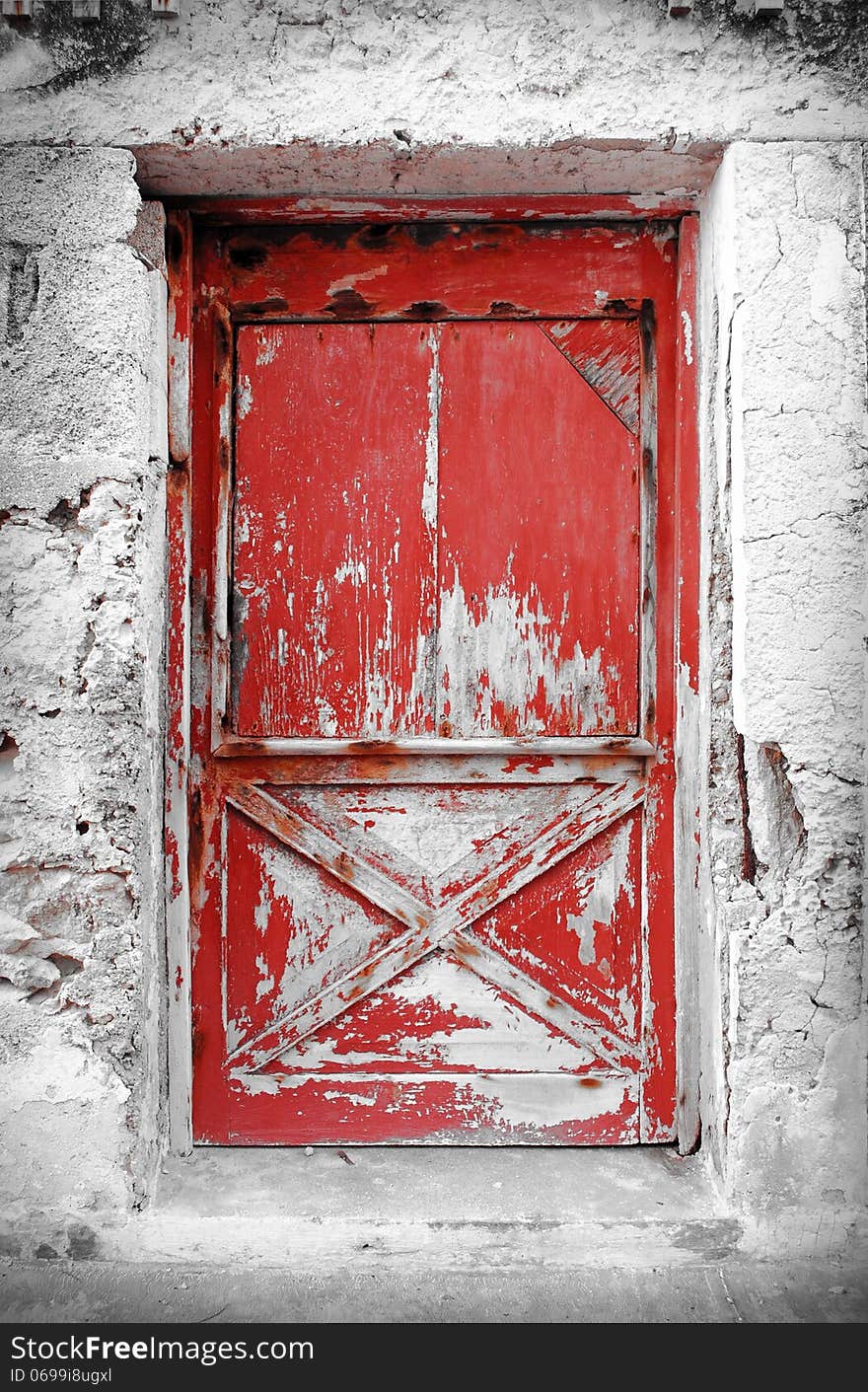 Red aged door on gray wall. Red aged door on gray wall