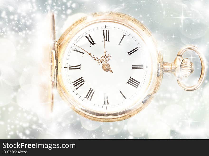 New Year's at midnight - Old golden clock with stars and snowflakes on the background. New Year's at midnight - Old golden clock with stars and snowflakes on the background