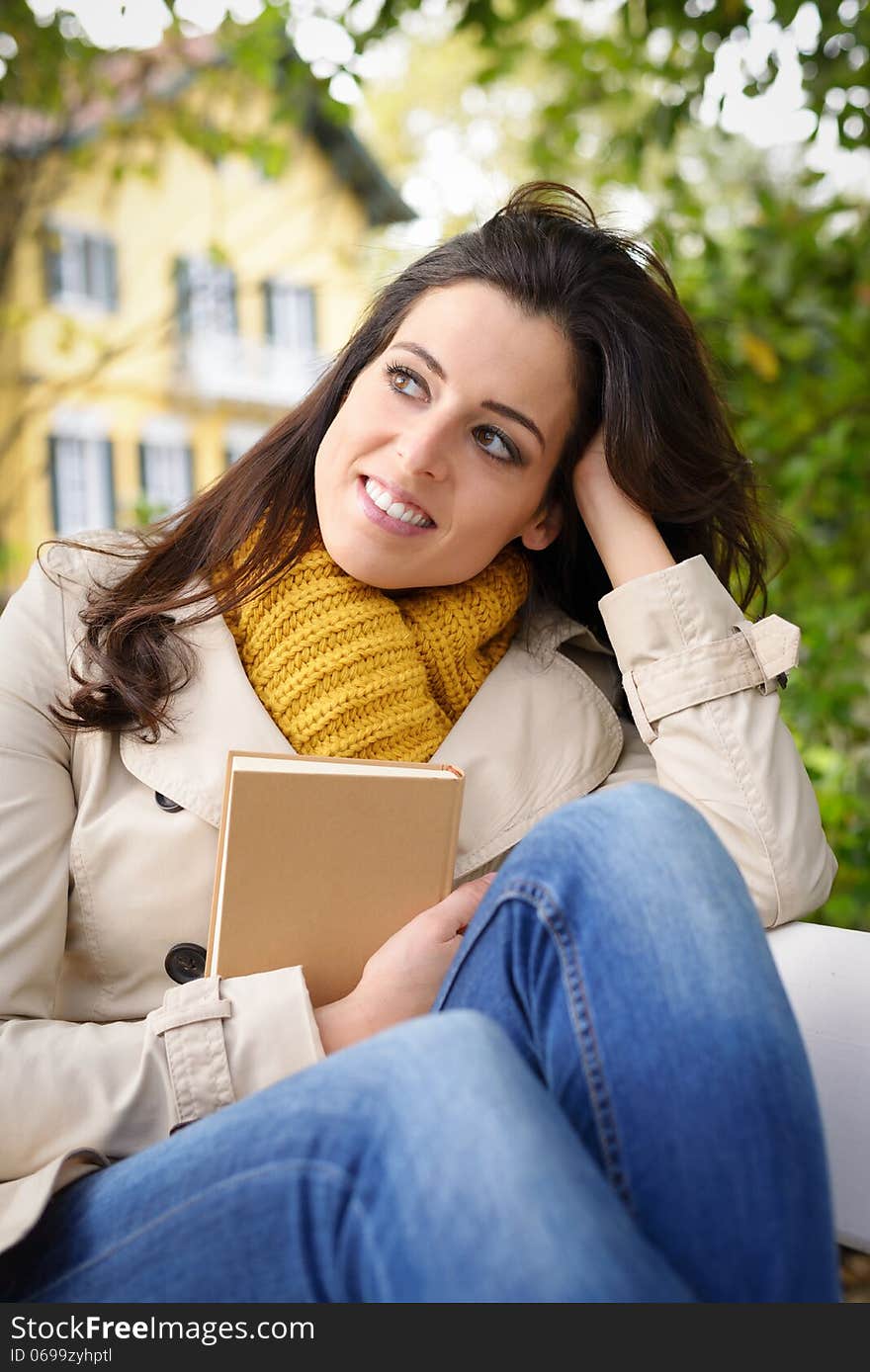 Woman reading book and day dreaming at home garden. Female enjoying relaxing lecture and tranquility in front of her country house. Woman reading book and day dreaming at home garden. Female enjoying relaxing lecture and tranquility in front of her country house.