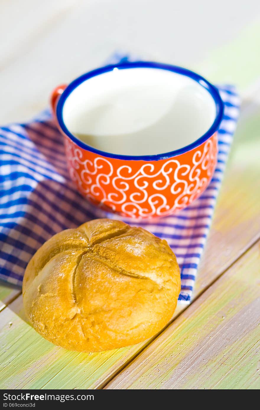 Cup of milk and bread on napkin