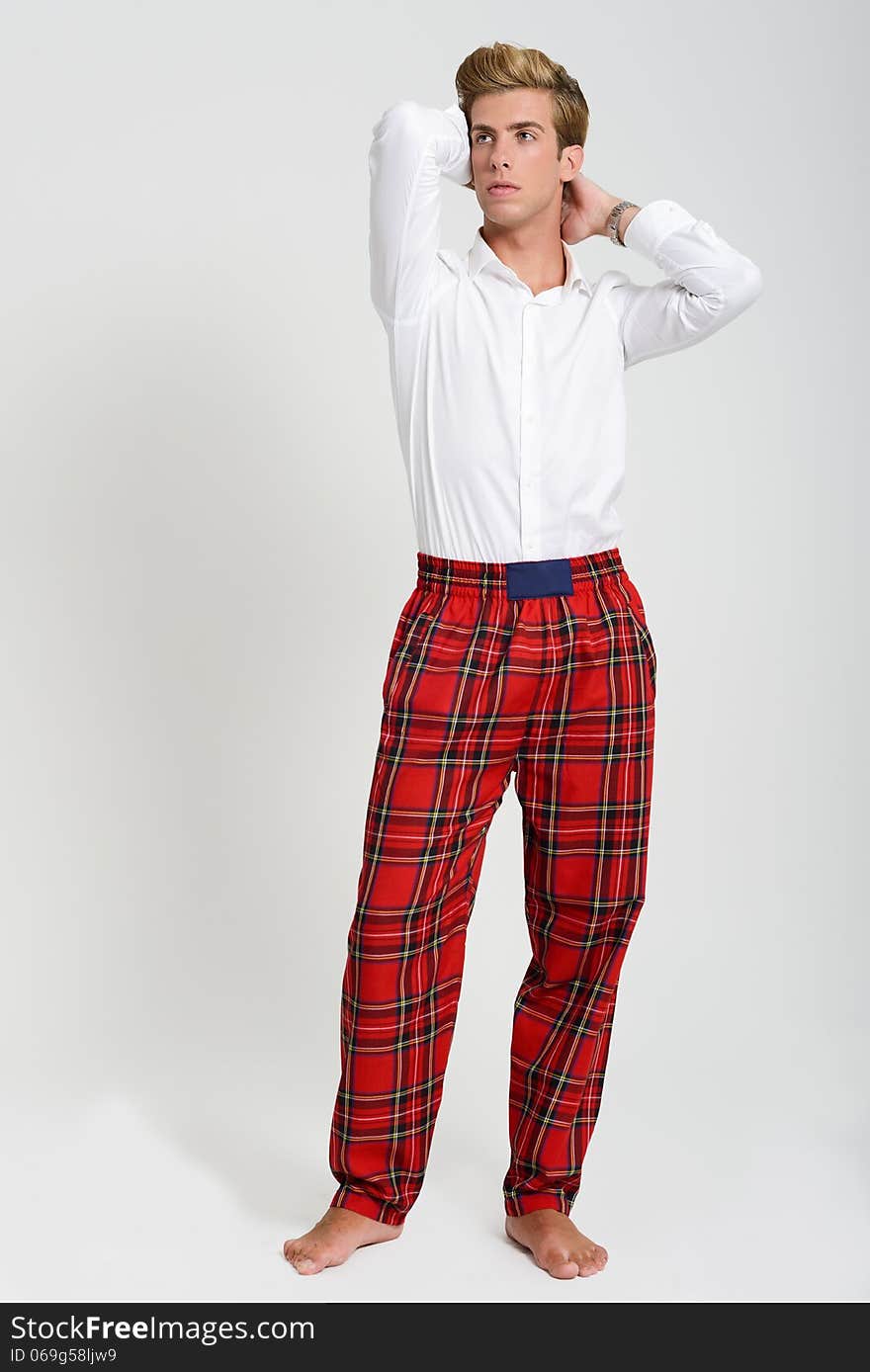 Handsome blonde man wearing white t-shirt and scottish pants