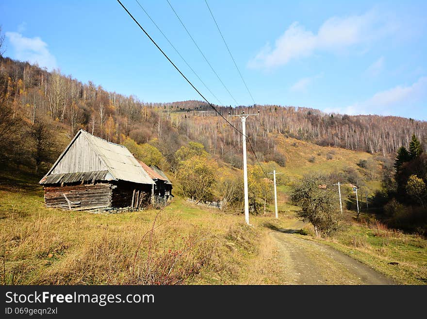 Country road and woode house in autumn