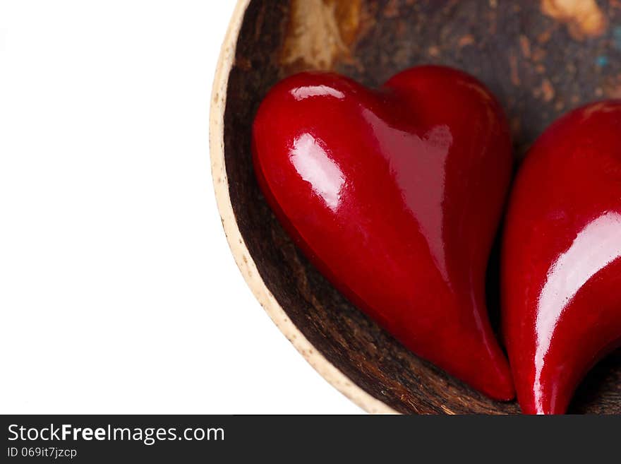 Two red hearts in a bowl of coconut, close-up, isolated