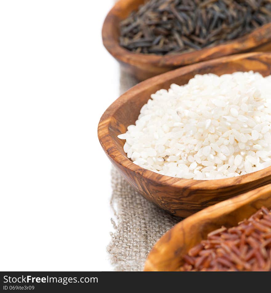 Wooden bowls with uncooked rice, selective focus, close-up, isolated on white