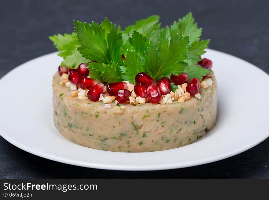 White bean pate with nuts and pomegranate on the plate