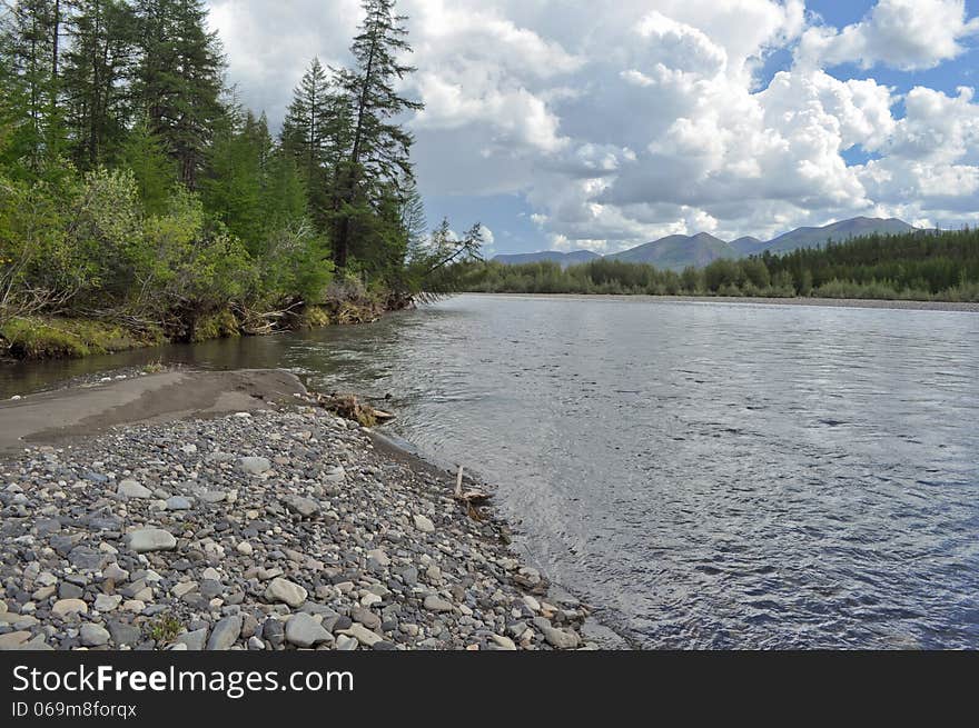 River flowing in a mountain valley. Landscape wildlife. Russia, Yakutia, a ridge of Suntar-khayata. River flowing in a mountain valley. Landscape wildlife. Russia, Yakutia, a ridge of Suntar-khayata.