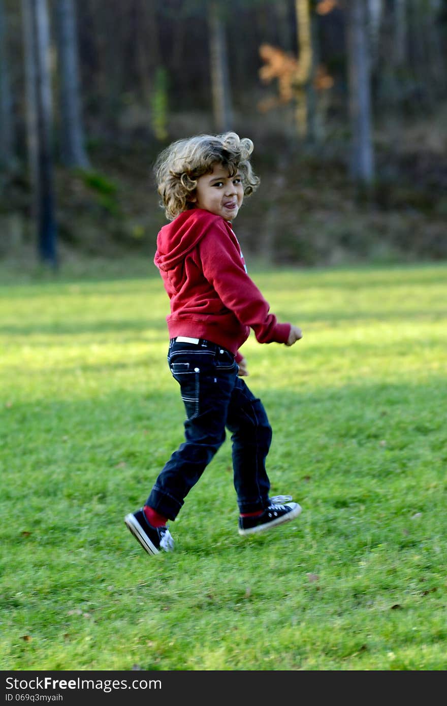 Kid playing in autumn sun by the lake. Kid playing in autumn sun by the lake