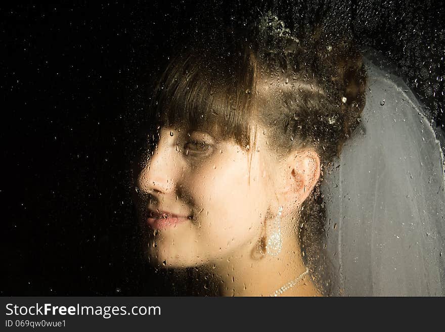 Drops of water on glass are in the focus area. Portrait of the girl is not in the focus area. Drops of water on glass are in the focus area. Portrait of the girl is not in the focus area.