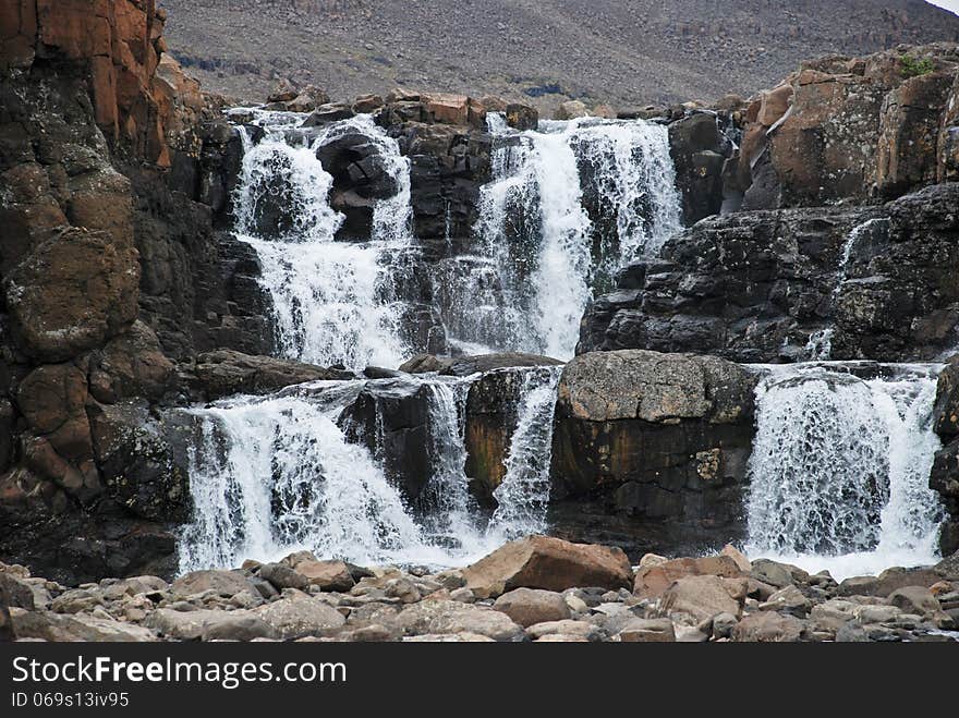 Landscape with rocks and a waterfall.