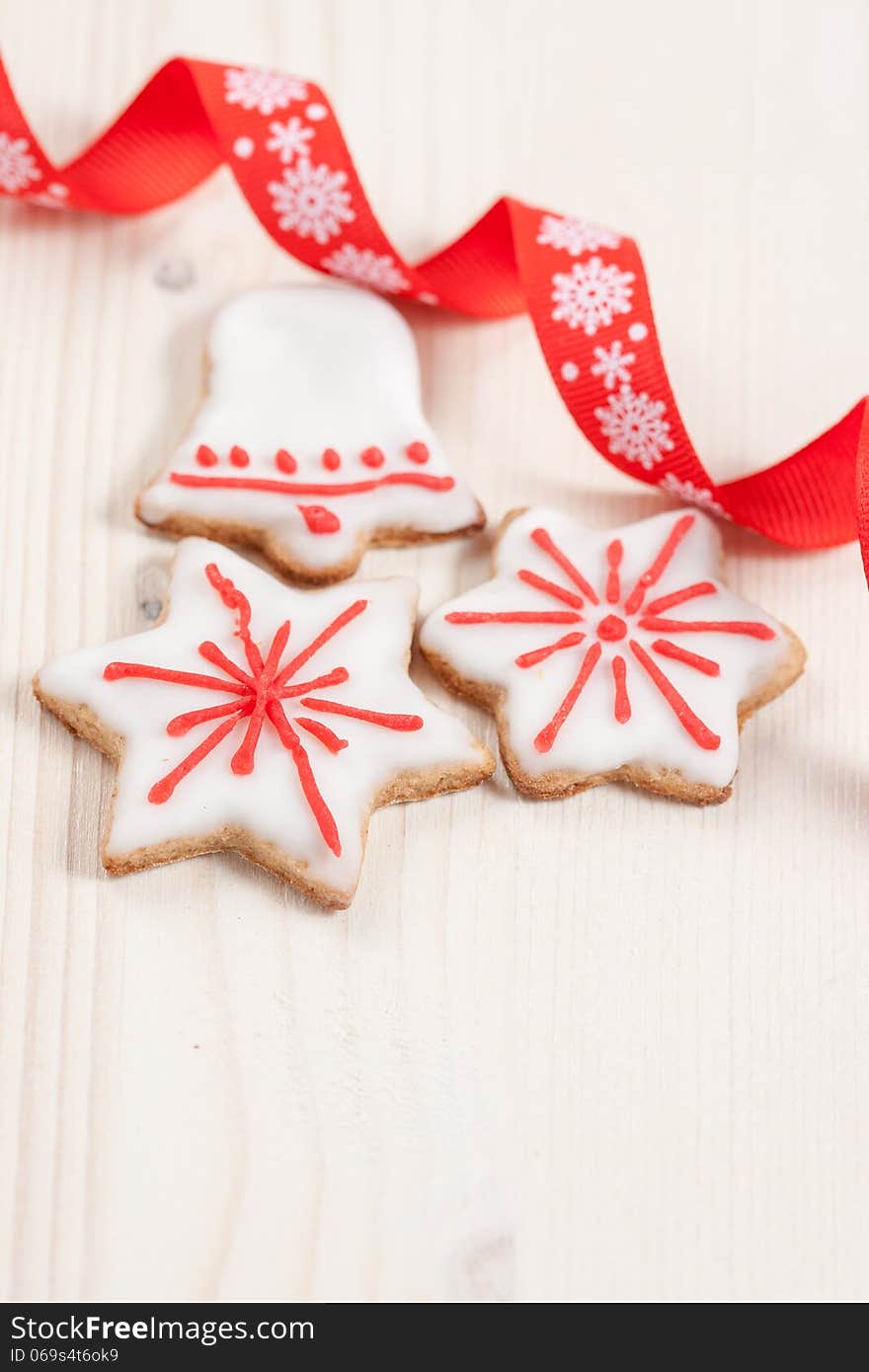 Christmas cookies in a white and red glaze on a white wooden background