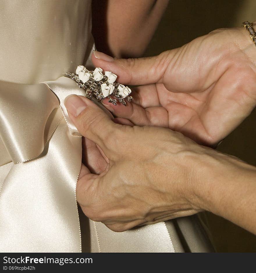 Mother of the bride pinning a broach on her daughters dress. Mother of the bride pinning a broach on her daughters dress