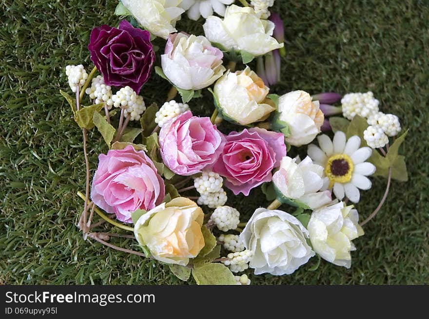 Close up flowers in heart shape on green grass. Close up flowers in heart shape on green grass