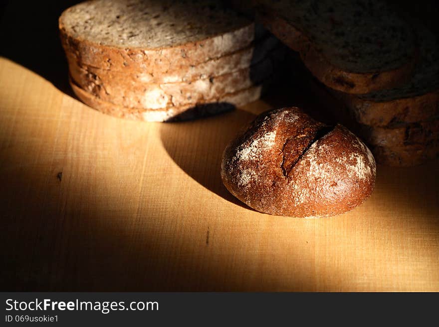 Set of bread on wooden board under beam of light