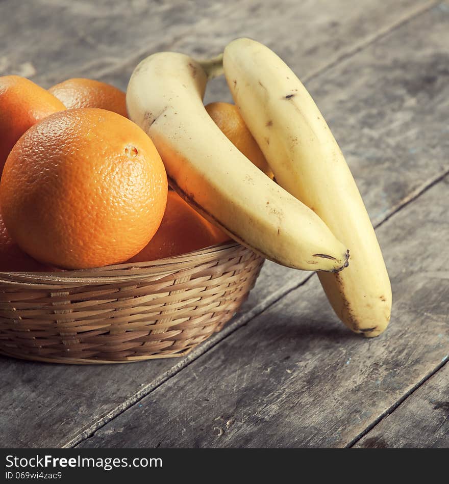 Basket of fruits on rustic, textured table. Basket of fruits on rustic, textured table