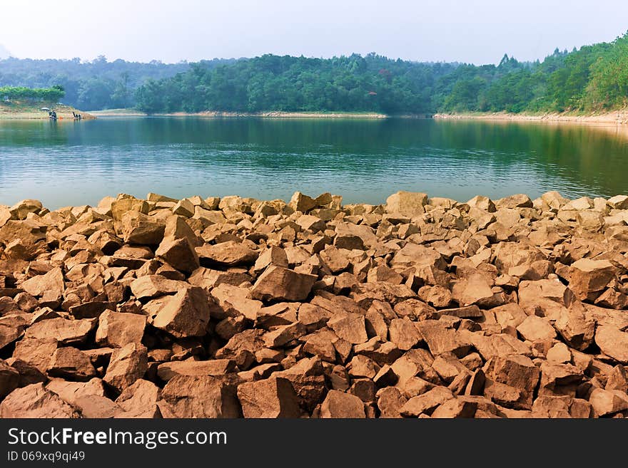 Natural lake in forest , rocky bank. Natural lake in forest , rocky bank