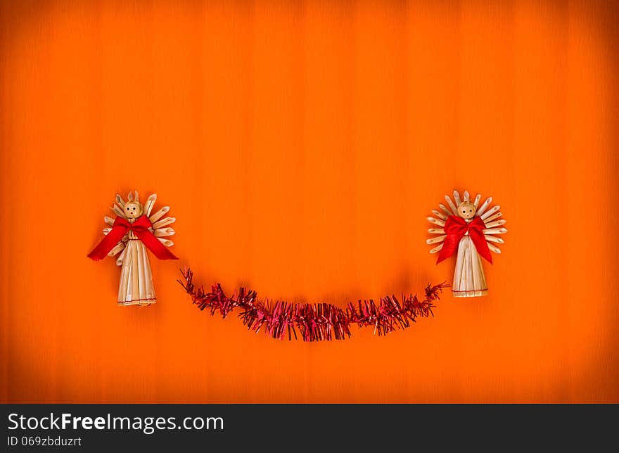 Orange Background for Christmas card with angels made ​​of straw