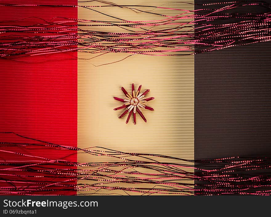 Background for Christmas greeting card- holiday straw decoration, red and yellow color textured paper