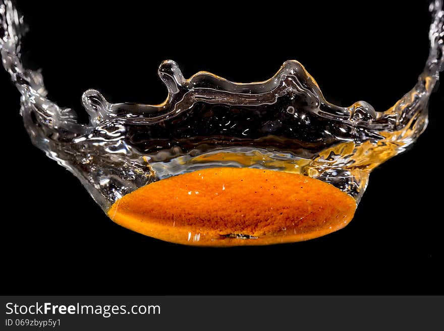 Slice of orange falling into the water. Slice of orange falling into the water