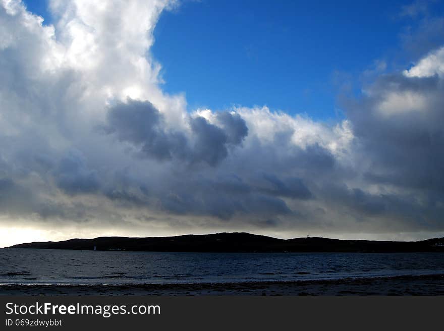 Beach, island and dramatic cloudy sky, Islay, Scotland. Beach, island and dramatic cloudy sky, Islay, Scotland