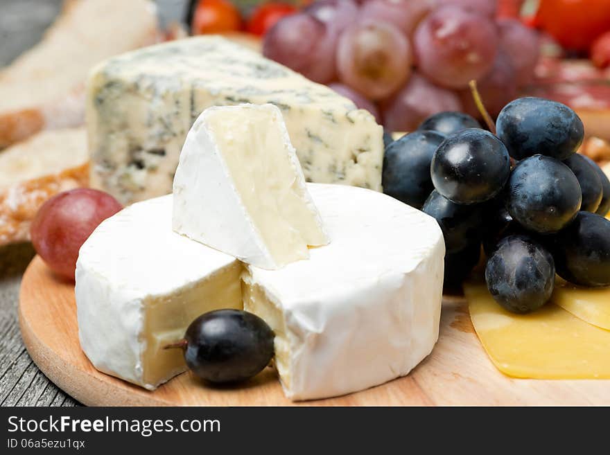 Camembert, blue cheese, grapes and walnuts, close-up, horizontal