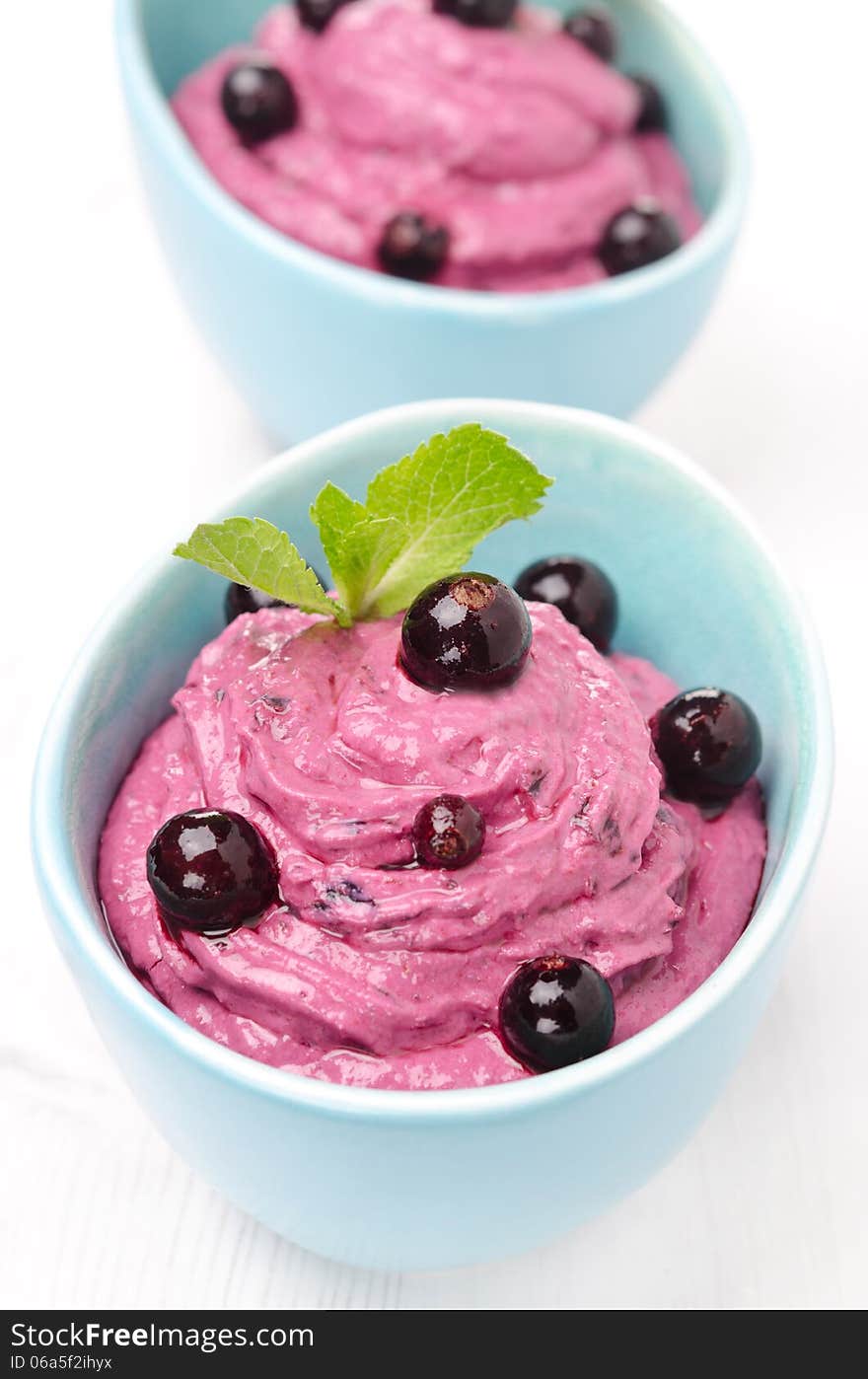 Close-up of black currant mousse with cream cheese in blue bowls